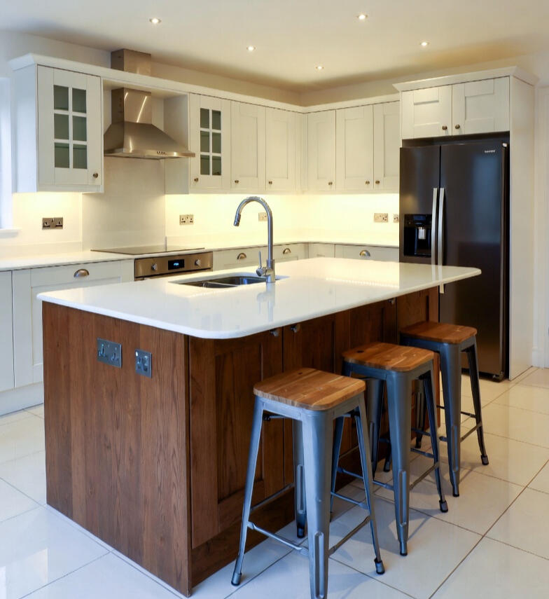 White kitchen with wood-effect island and bar stools White kitchen with wood-effect island and bar stools