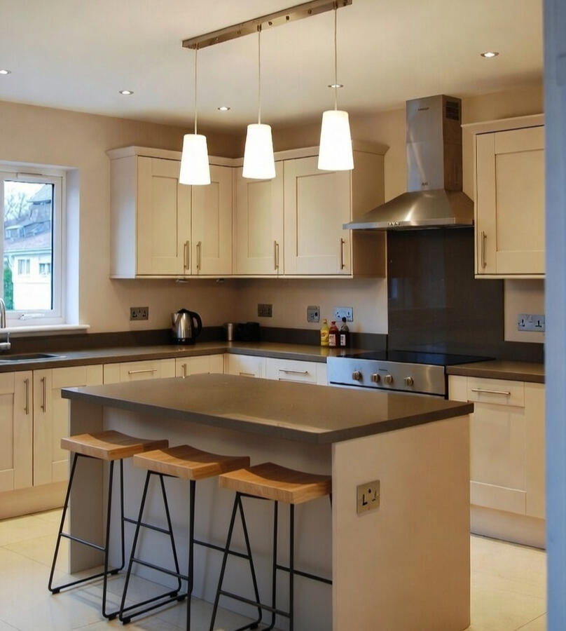 Cream kitchen with island, bar stools and extractor hood Cream kitchen with island, bar stools and extractor hood